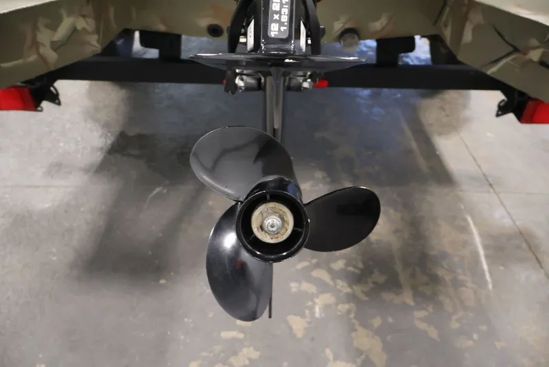 Slide: The Image of 2024 Tracker Grizzly 1860 MVX CC boat propeller, close-up view in a garage setting. - 28