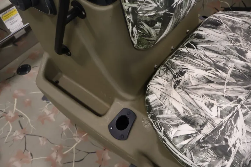 Slide: The Image of 2024 Tracker Grizzly 1860 MVX CC boat interior with camouflage seating and storage compartment. - 24