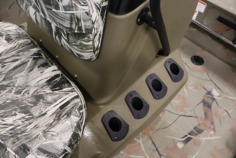Slide: The Image of 2024 Tracker Grizzly 1860 MVX CC boat interior with camo seats and rod holders. - 14