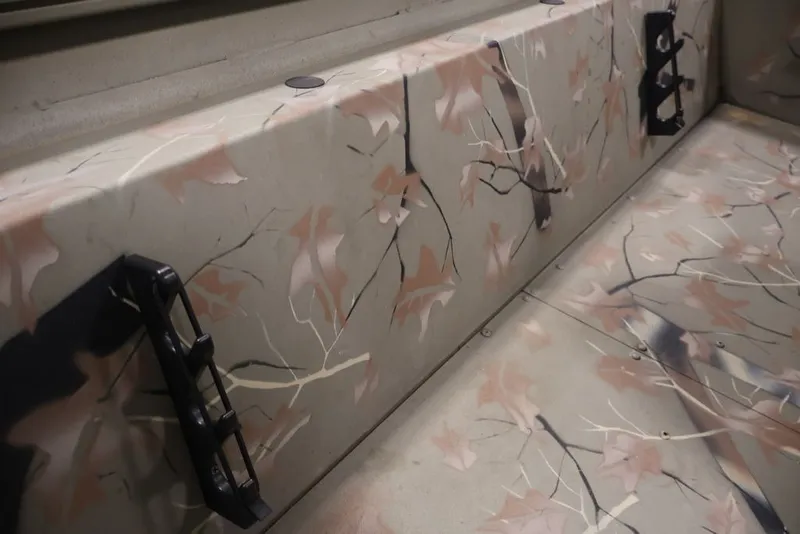 Slide: The Image of 2024 Tracker Grizzly 1860 MVX CC interior with camouflage leaf pattern design. - 21