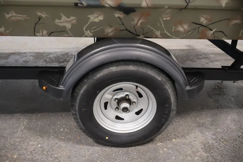 Slide: The Image of Trailer wheel of 2024 Tracker Grizzly 1860 MVX CC with camouflage design. - 30