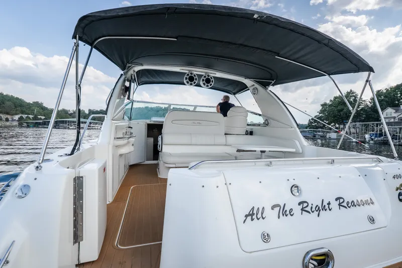 Slide: The Image of 1997 Sea Ray Sundancer 400 yacht with canopy, docked on a serene lake. - 20