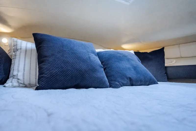 Slide: The Image of Cozy cabin interior of 1997 Sea Ray Sundancer 400 with blue and white pillows. - 55