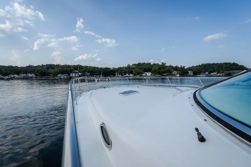 Slide: The Image of 1997 Sea Ray Sundancer 400 yacht cruising on a serene lake under a clear blue sky. - 64