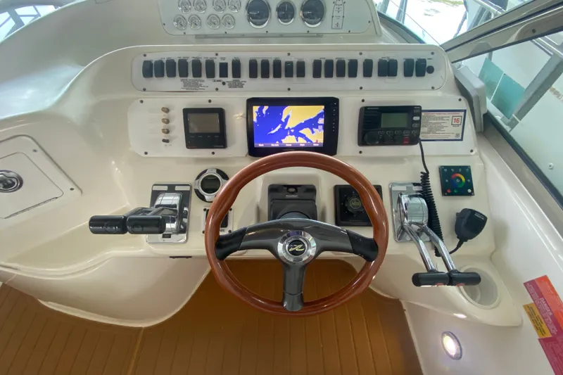 Slide: The Image of 1997 Sea Ray 40 Sundancer helm with navigation controls and wooden steering wheel. - 30