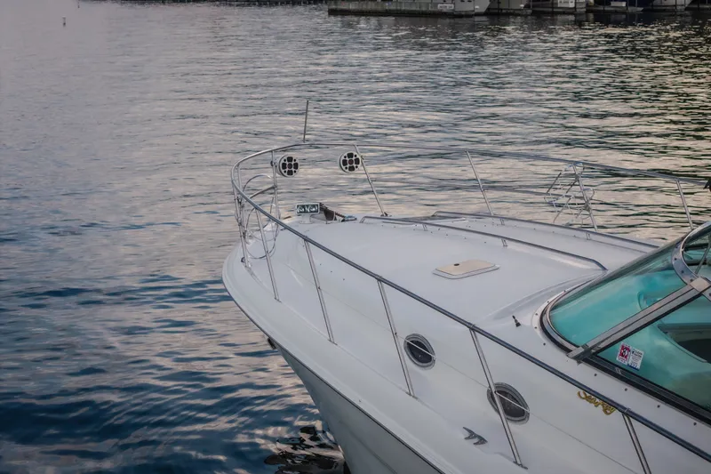 Slide: The Image of 1997 Sea Ray Sundancer 400 yacht on calm water near a marina. - 67