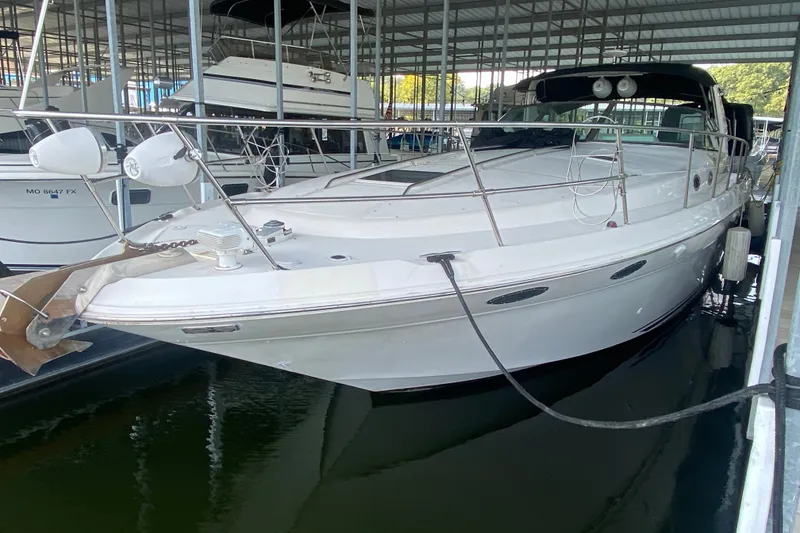 Slide: The Image of 1997 Sea Ray 40 Sundancer docked in a marina, featuring sleek white design. - 44