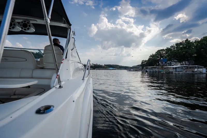 Slide: The Image of 1997 Sea Ray Sundancer 400 cruising on a serene lake under a partly cloudy sky. - 22
