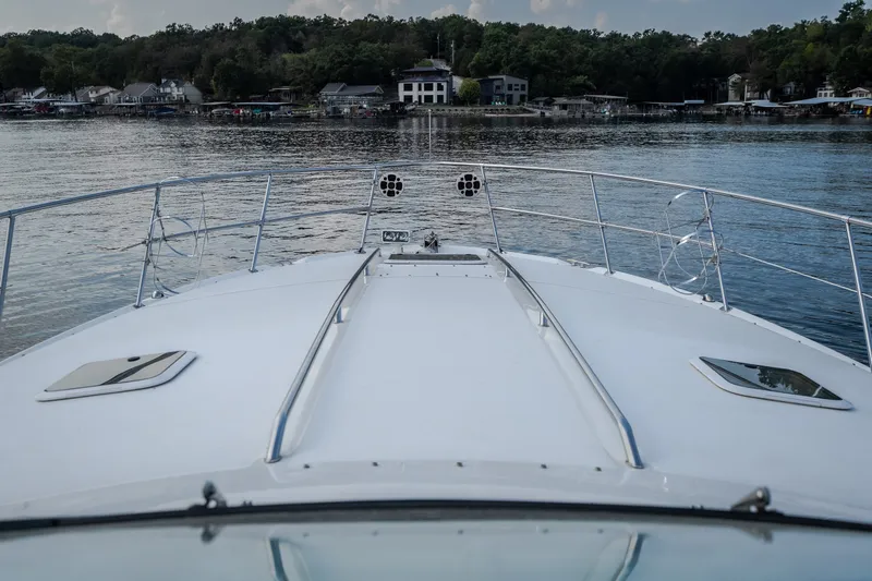 Slide: The Image of Bow view of 1997 Sea Ray Sundancer 400 yacht on a serene lake. - 62