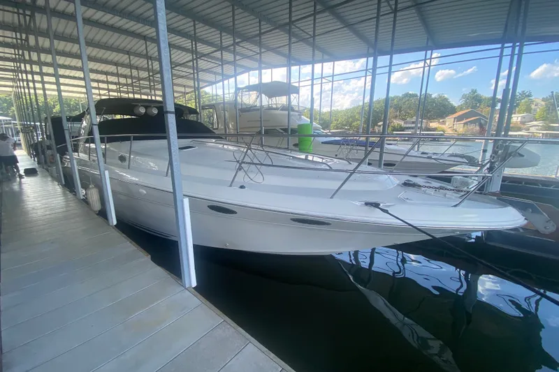 Slide: The Image of 1997 Sea Ray 40 Sundancer docked in a covered marina, reflecting on calm water. - 39