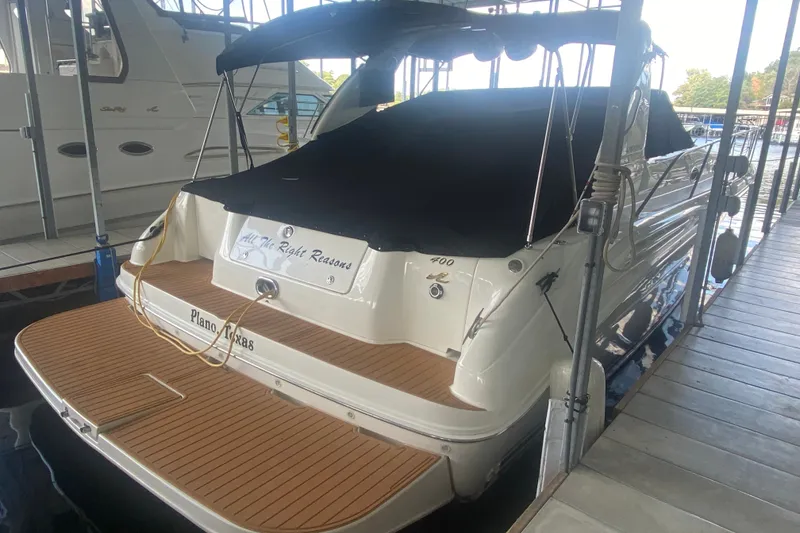 Slide: The Image of 1997 Sea Ray 40 Sundancer docked, covered, with teak swim platform, in marina setting. - 40