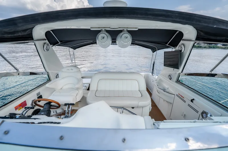 Slide: The Image of 1997 Sea Ray Sundancer 400 yacht interior with white seating and helm, overlooking calm waters. - 31
