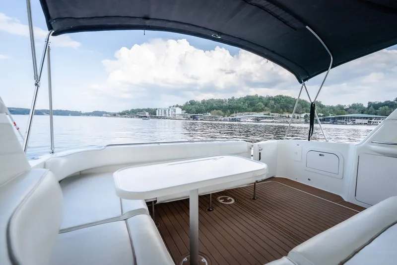Slide: The Image of 1997 Sea Ray Sundancer 400 yacht interior with seating and table, overlooking serene waters. - 17