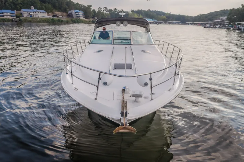 The Image of 1997 Sea Ray Sundancer 400 yacht on calm water, surrounded by scenic landscape. - 1