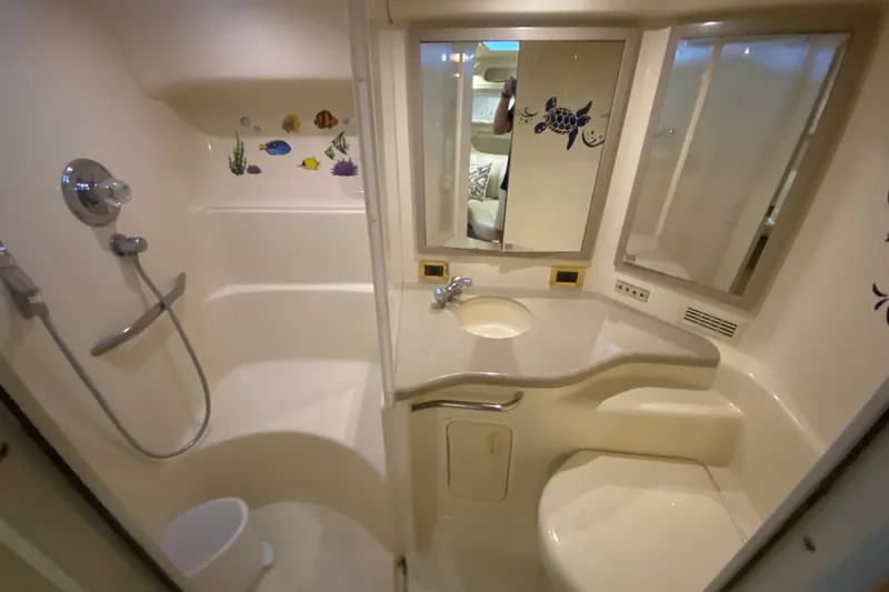 Slide: The Image of 1997 Sea Ray 40 Sundancer bathroom with shower, sink, and marine-themed decor. - 33