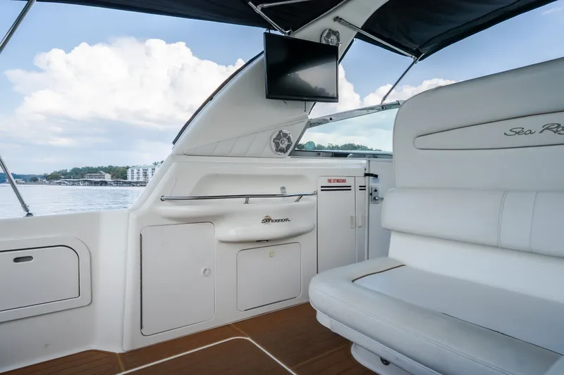 Slide: The Image of 1997 Sea Ray Sundancer 400 interior with white seating, TV, and scenic water view. - 18