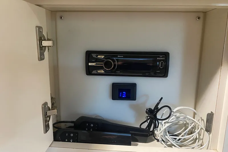 Slide: The Image of Sony stereo system in a 1997 Sea Ray 40 Sundancer cabinet with remote controls and cables. - 26