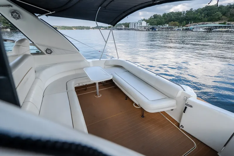 Slide: The Image of 1997 Sea Ray Sundancer 400 yacht interior with white seating and table, overlooking serene waters. - 38