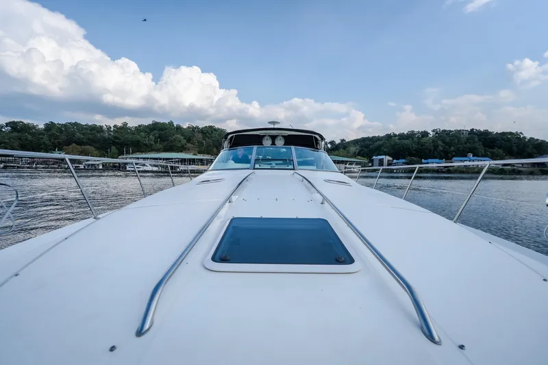 Slide: The Image of 1997 Sea Ray Sundancer 400 yacht on calm water, under a partly cloudy sky. - 30