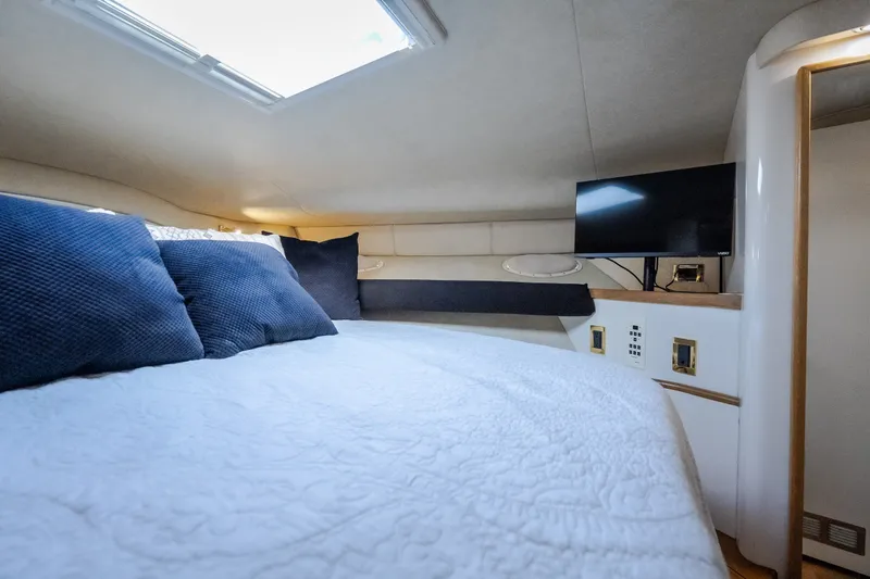 Slide: The Image of Cozy cabin interior of 1997 Sea Ray Sundancer 400 with bed, pillows, and TV. - 54