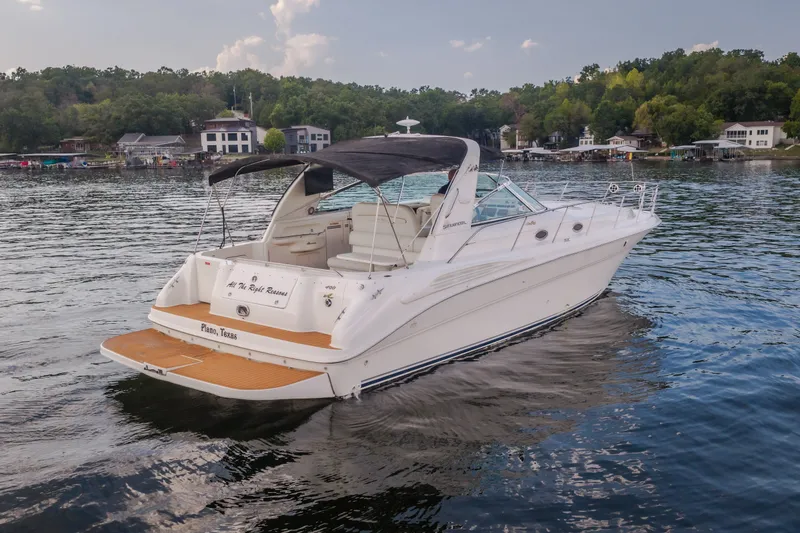 Slide: The Image of 1997 Sea Ray Sundancer 400 yacht on a serene lake, surrounded by lush greenery. - 4
