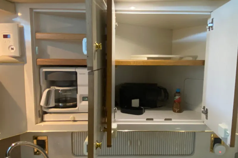 Slide: The Image of Kitchen area in a 1997 Sea Ray 40 Sundancer yacht with coffee maker and storage. - 15