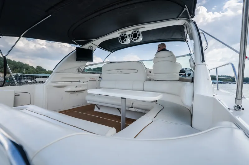 Slide: The Image of 1997 Sea Ray Sundancer 400 yacht interior with white seating and table, under a canopy. - 23