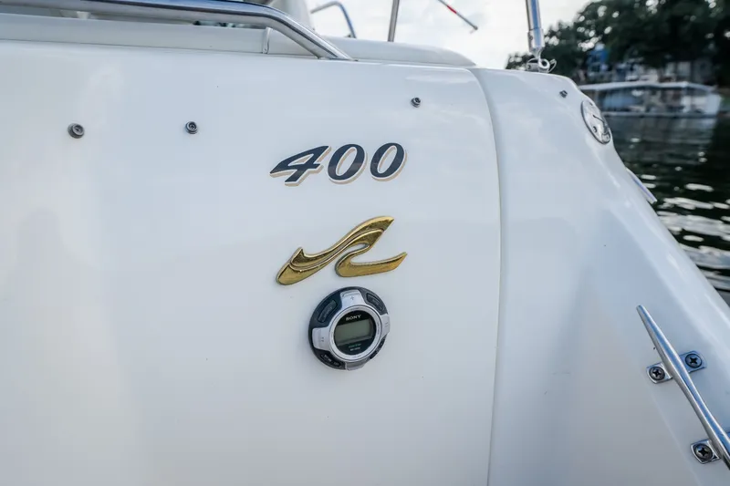 Slide: The Image of 1997 Sea Ray Sundancer 400 boat with model emblem and water backdrop. - 21
