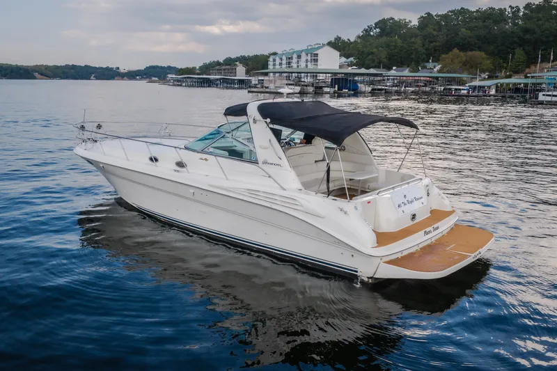 Slide: The Image of 1997 Sea Ray Sundancer 400 yacht cruising on a serene lake near a marina. - 3