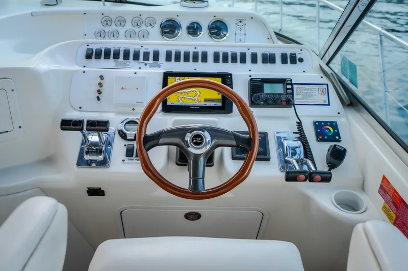 Slide: The Image of Cockpit of 1997 Sea Ray Sundancer 400 with steering wheel and navigation controls. - 12
