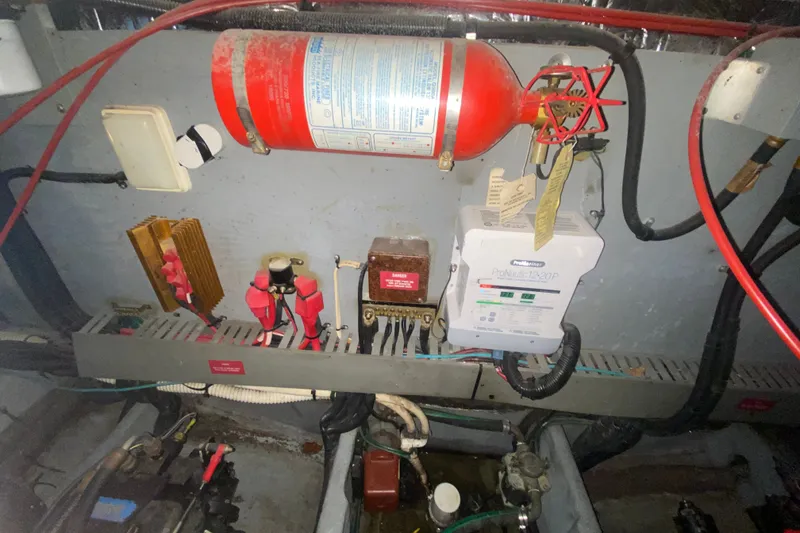 Slide: The Image of Engine room of 1997 Sea Ray Sundancer 400 with fire extinguisher and electrical components. - 76