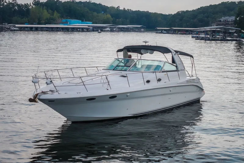 Slide: The Image of 1997 Sea Ray Sundancer 400 yacht cruising on a serene lake with wooded shoreline. - 2