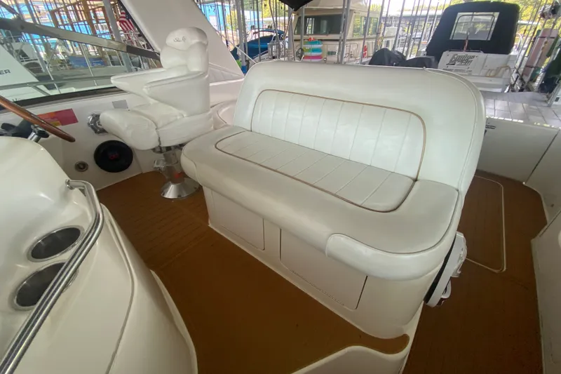 Slide: The Image of Interior of a 1997 Sea Ray 40 Sundancer yacht with white seating and helm chair. - 28