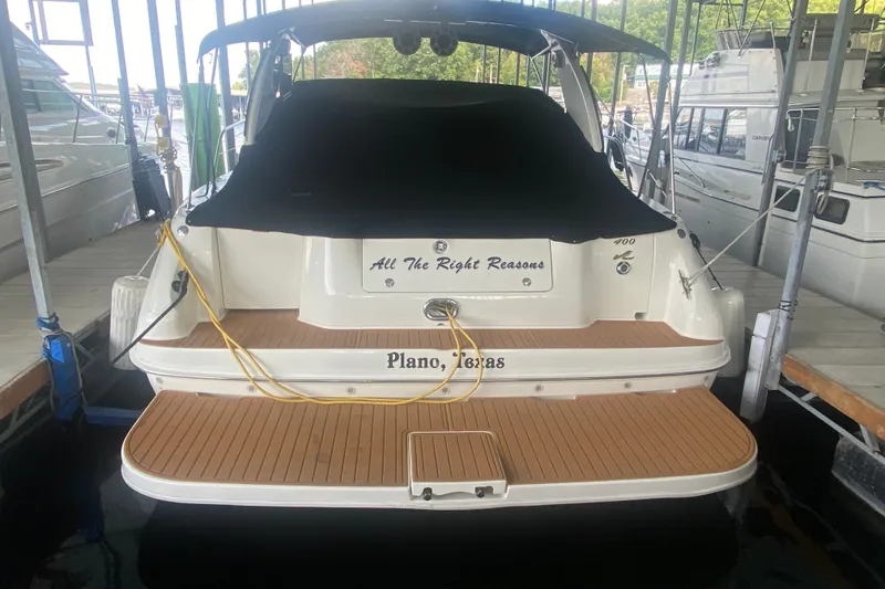Slide: The Image of 1997 Sea Ray 40 Sundancer docked, featuring teak swim platform and black canvas cover. - 41