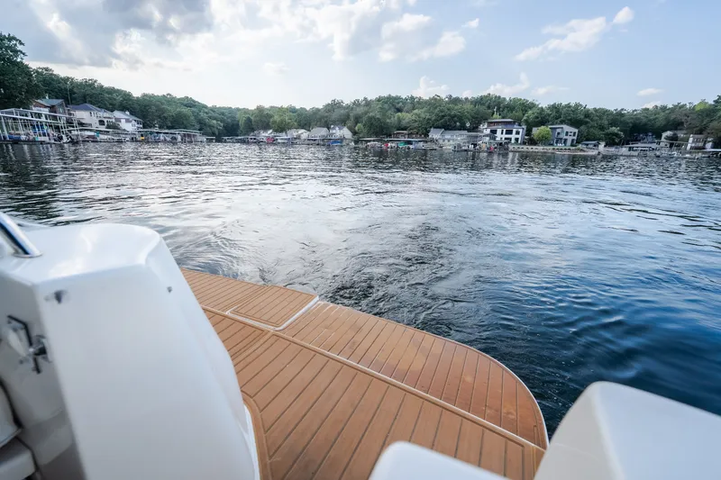 Slide: The Image of 1997 Sea Ray Sundancer 400 on serene lake with scenic shoreline view. - 19