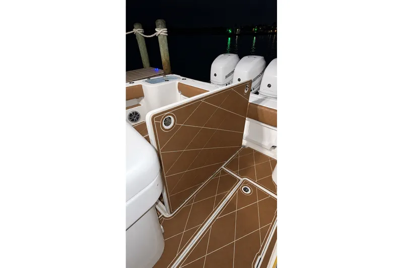 Slide: The Image of 2008 Grady-White Express 330 boat deck with brown cushioned flooring and outboard motors. - 54