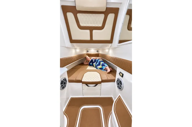 Slide: The Image of 2008 Grady-White Express 330 cabin interior with person relaxing on cushioned seating. - 46