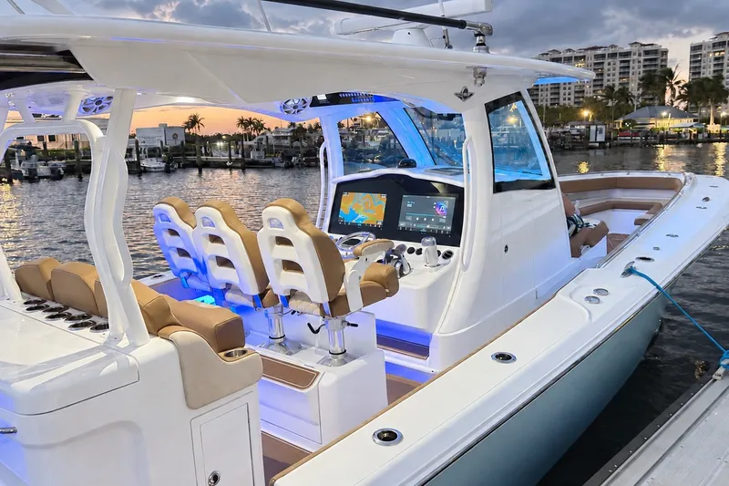 Slide: The Image of 2008 Grady-White Express 330 boat docked at sunset, featuring modern cockpit and seating. - 7