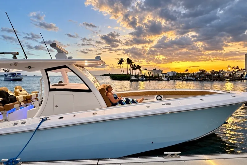 Slide: The Image of 2008 Grady-White Express 330 boat at sunset, docked near palm trees and waterfront homes. - 21