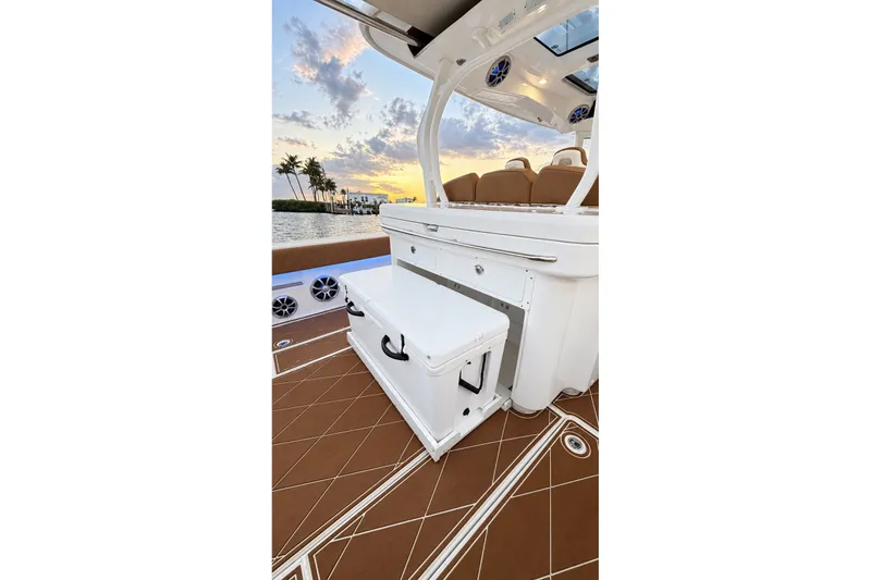 Slide: The Image of 2008 Grady-White Express 330 boat interior with sunset view, featuring seating and storage. - 52