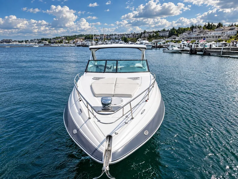 Slide: The Image of A 2020 Cruisers Yachts 35 Express on the water, with a scenic harbor in the background. - 5