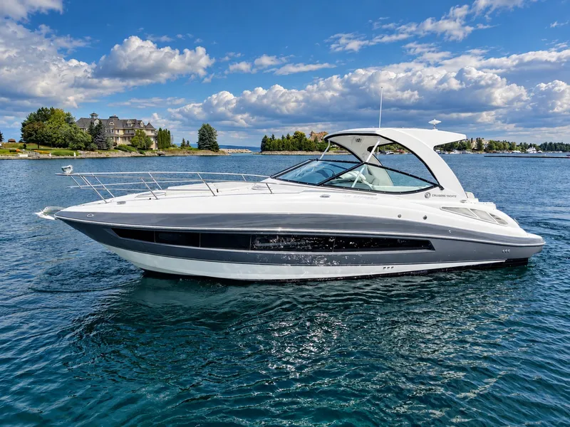 Slide: The Image of A sleek white motor yacht with a curved design cruises on calm water. Houses and trees are visible in the background. - 9