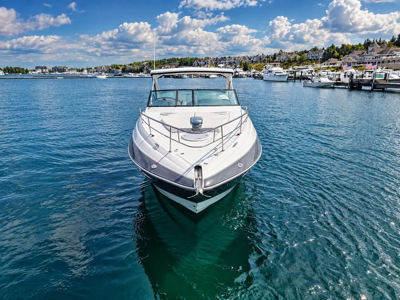 Slide: The Image of A 2020 Cruisers Yachts 35 Express sits in clear harbor waters under a blue sky. - 7