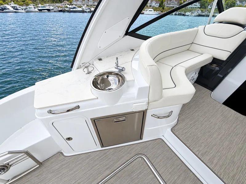 Slide: The Image of The 2020 Cruisers Yachts 35 Express features an elegant seating area with white upholstery and a small sink. - 24