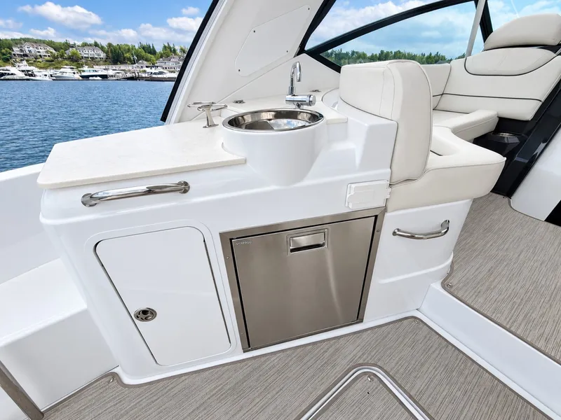 Slide: The Image of The 2020 Cruisers Yachts 35 Express features a sleek outdoor kitchenette with a sink and storage. - 25