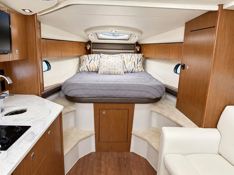 Slide: The Image of The cabin of a 2020 Cruisers Yachts 35 Express with a cozy bed and wooden cabinetry. - 39