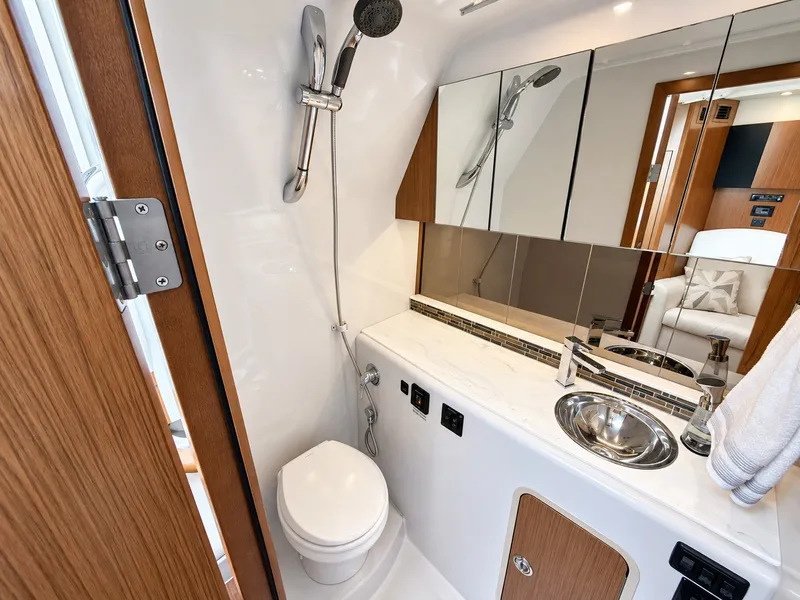 Slide: The Image of The image shows a modern yacht bathroom with a toilet, sink, and shower. - 48
