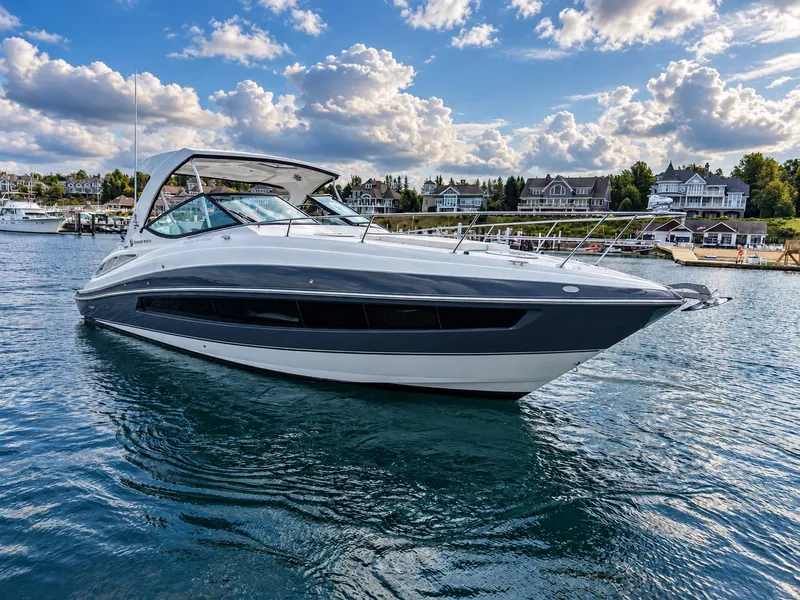 Slide: The Image of A sleek 2020 Cruisers Yachts 35 Express on calm water near a picturesque shoreline. - 4