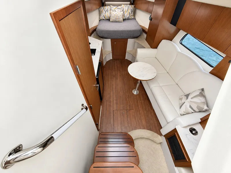 Slide: The Image of Interior of a 2020 Cruisers Yachts 35 Express with cozy sofa and sleeping area. - 38