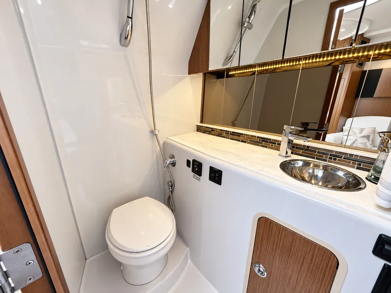 Slide: The Image of The image shows a modern yacht bathroom with a toilet, sink, and mirror. - 49